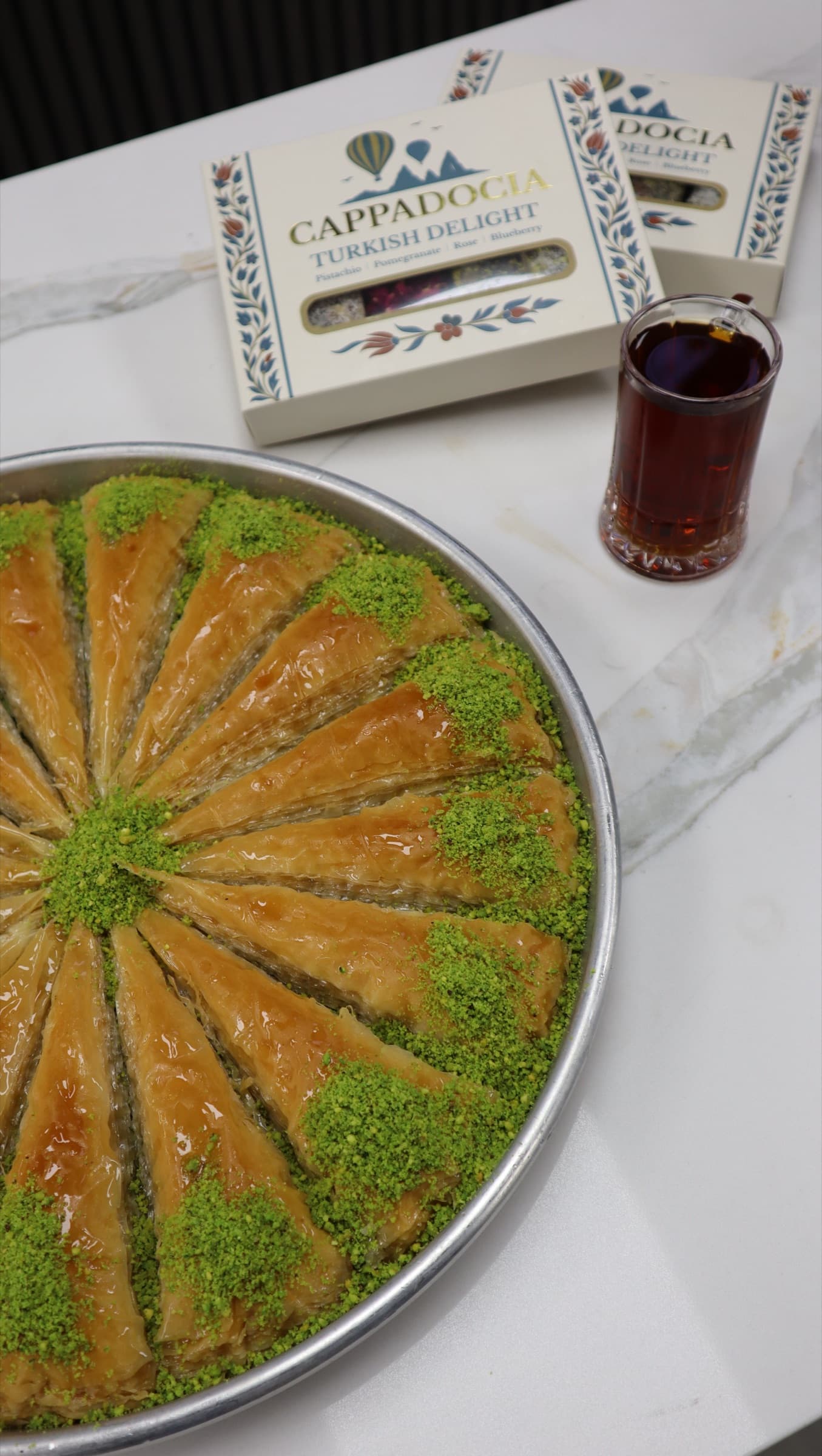 A round tray of baklava with Turkish tea