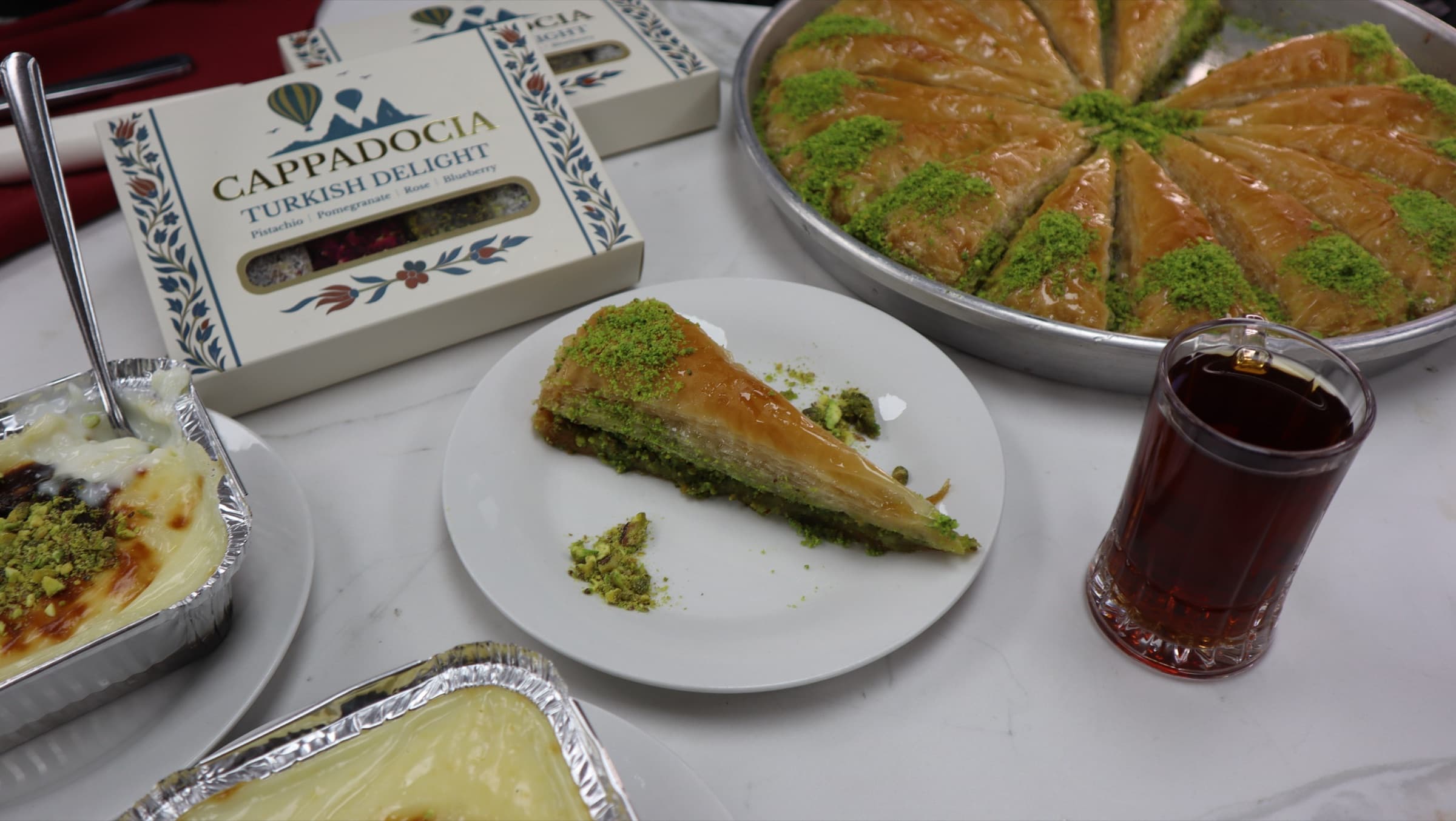 A slice of baklava on a plate with tea